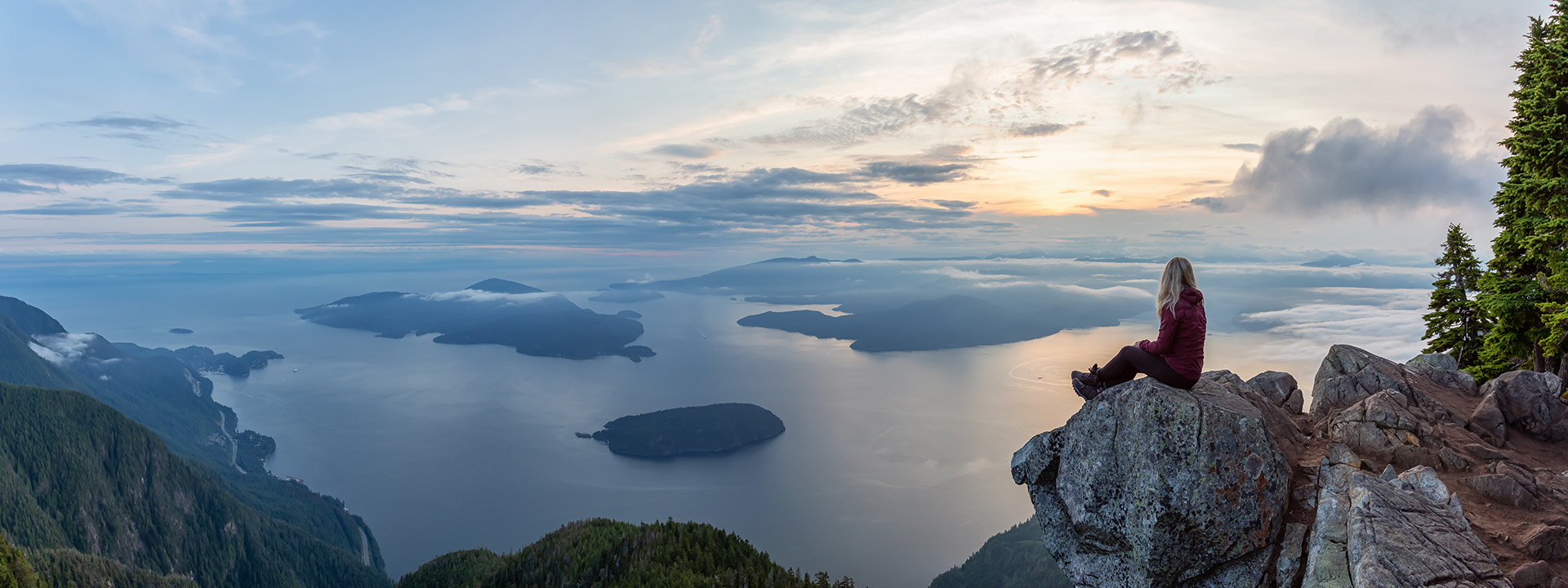 Woman on the top of a mountain looking the sunset